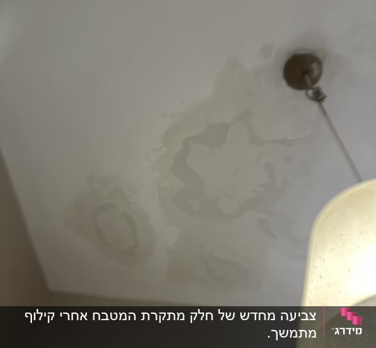 כתמי רטיבות על תקרה ליד מנורה